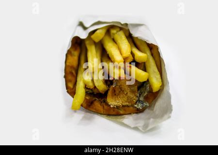 Gyros greci avvolti in pita pane isolato su sfondo bianco. Fast food. Gyros con carne, patatine fritte e insalata tzatziki Foto Stock