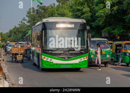 New Delhi, India. 20 Ott 2021. Un autobus elettrico apre la sua strada su un tipico indiano affollato Road.Cashless Feeder servizio di autobus elettrico introdotto per la prima volta a Delhi su una base di prova da Delhi Metro Rail Corporation. Credit: SOPA Images Limited/Alamy Live News Foto Stock