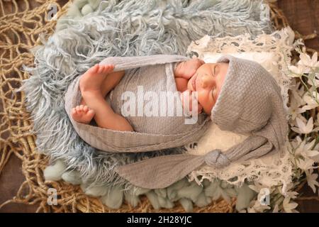 6 mesi bambina dolce arabo musulmana ragazza che posa e posa su una comoda lana cute viso vista dall'alto ritratto grigio sciarpa morbida Foto Stock