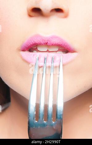 bocca della donna che mangia con una forchetta Foto Stock