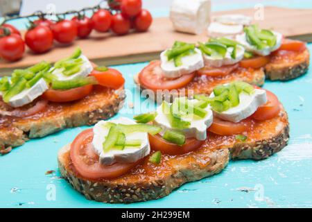 Toast al pomodoro con avocado e rotolo di capra per vegani Foto Stock