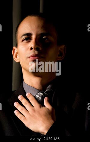 Attore in piedi che rappresenta un personaggio in un teatro. Sfondo nero nella scena. Salvador Bahia Brasile. Foto Stock