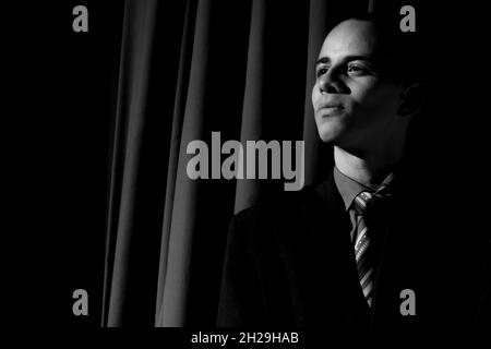 Attore in piedi che rappresenta un personaggio in un teatro. Sfondo nero nella scena. Salvador Bahia Brasile. Foto Stock