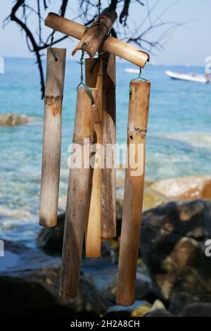 Closeup colpo di bambù vento chimes sullo sfondo del mare. Foto Stock