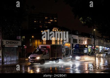 Londra, Regno Unito. 20 Ott 2021. I veicoli sono visti passare attraverso la strada allagata nel sud-est di Londra. La pioggia tropicale pesante ha influenzato l'area est e sud est di Londra, parte di Kent e Essex in serata. Alcune zone sono in attesa di inondazioni. Credit: SOPA Images Limited/Alamy Live News Foto Stock