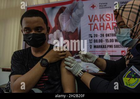 Palu, Sulawesi Centrale, Indonesia. 21 ottobre 2021. Il governo indonesiano continua ad accelerare il programma di vaccinazione del Covid-19 verso zone remote per raggiungere l'obiettivo del 80% delle persone vaccinate entro la fine di dicembre 2021. Questo sforzo è supportato dall'assistenza vaccinale astrazeneca fornita da Giappone e Australia fino a 1.7 milioni di dosi. (Credit Image: © Adi PranataZUMA Wire) Foto Stock