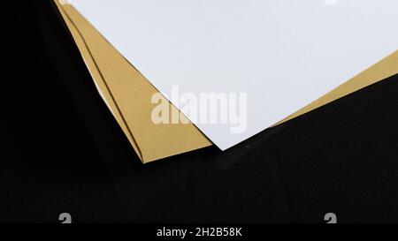 Primo piano di un foglio di carta e di una busta isolata su sfondo nero Foto Stock