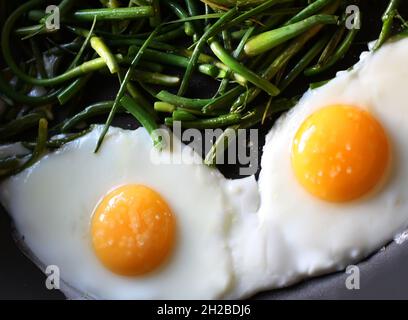 Uova fritte con fagioli verdi sulla padella da vicino Foto Stock