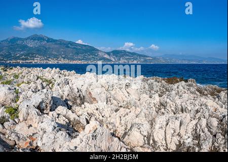 La vista da Cap Martin attraverso il Mar Mediterraneo alla plage de Carnolès e Menton in lontananza Foto Stock