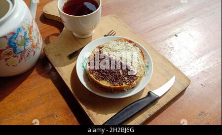 Martabak con condimento al cioccolato e formaggio grattugiato con una tazza di tè Foto Stock