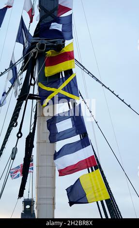 Bandiere di segnale che fanno parte del messaggio emesso dall'ammiraglio Lord Nelson, 'l'Inghilterra si aspetta che ogni uomo farà il suo dovere' sono sollevate su uno dei montanti a bordo della HMS Victory di Portsmouth prima di una cerimonia per celebrare il 216 ° anniversario della battaglia di Trafalgar. Data foto: Giovedì 21 ottobre 2021. Foto Stock