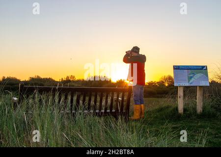 Southport, Merseyside. Meteo Regno Unito. 21 Ott 2021. Durante la notte temperature fredde di 7C e cieli limpidi come il sole sorge sopra la RSPB Marshside importante riserva naturale paludosa. Un luogo preferito dagli appassionati di birdwatching per vedere i greggi migratori di anatre e oche che si innalzano dai terreni di alimentazione. La riserva è utilizzata da un gran numero di oche rosa che si aggirano, provenienti dall'Islanda, e da una riserva naturale, parte della Riserva Naturale del Parco Regionale dei Ribble, uno dei più grandi terreni di allevamento di uccelli che si radono nel Regno Unito e riconosciuto a livello internazionale. Credit; MediaWorldImages/AlamyLiveNews Foto Stock