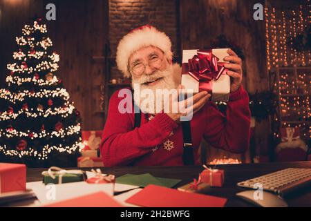 Foto ritratto babbo natale mantenere presente scatola sorridente overjoyed indossare occhiali Foto Stock