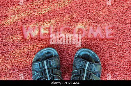 Benvenuti porta capet con piedi ware su di esso. Foto Stock