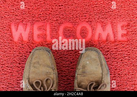 Benvenuti porta capet con piedi ware su di esso. Foto Stock