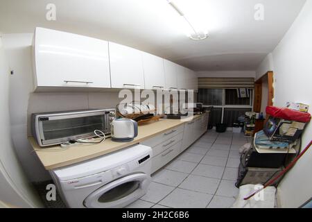 Cucina tradizionale dettaglio in nuova casa di lusso con lavello casa colonica, pavimenti in legno, travi in legno, grande isola e quarzo Foto Stock