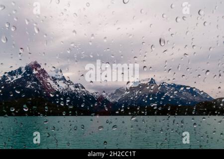 Gocce d'acqua sulla finestra di una barca che attraversa il lago di Pehoe di fronte al Cuernos del Paine. Ultima Esperanza Cile Foto Stock