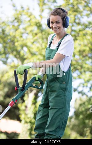 L'uomo mows l'erba del prato con un tosaerba Foto Stock