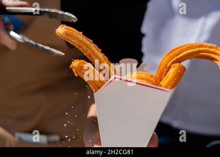 Churros croccanti fatti in casa in scatola di carta bianca - primo piano Foto Stock