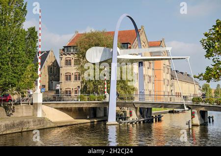 Leeuwarden, Paesi Bassi, 10 ottobre 2021: Moderno ponte Blokhuispoort attraverso il canale Zuiderstadsgracht con l'ex prigione Blokhuispoort sul retro Foto Stock