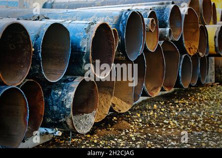 I vecchi tubi usurati per la gassificazione sono disposti in fila. Smaltimento di rottami metallici. Background industriale. Foto Stock