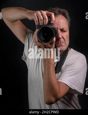 Un fotografo professionista ritratto a mezza lunghezza mentre si scatta una foto Foto Stock