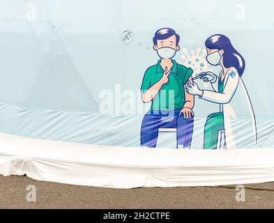 Cartoon che mostra medico femminile vaccinare il vostro paziente maschio in maschera facciale. Vaccinare l'annuncio sulla tenda medica a San Pietroburgo Russia Foto Stock