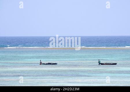 2 pescatori locali tirano la canoa. Zanzibar, Tanzania, Africa Foto Stock