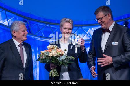 Rostock, Germania. 21 ottobre 2021. Manuela Schwesig (SPD), Presidente del Ministro Meclemburgo-Pomerania occidentale, è in scena all'accoglienza annuale della Camera dell'industria e del commercio di Rostock con l'ex Presidente federale Joachim Gauck (l) e Klaus-Jürgen Strupp, Presidente della Camera dell'industria e del commercio. Sotto il motto "V is Wow", la Camera dell'industria e del commercio di Rostock invita politici e imprenditori alla Stadthalle. Credit: Jens Büttner/dpa-Zentralbild/dpa/Alamy Live News Foto Stock