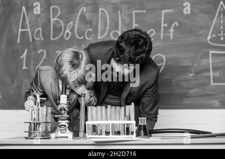 Abbiamo apprezzato l'innovazione, figlio e padre a scuola. Saggezza. Torna a scuola. Chimica e biologia fisica. Matraccio in mano allo scienziato Foto Stock