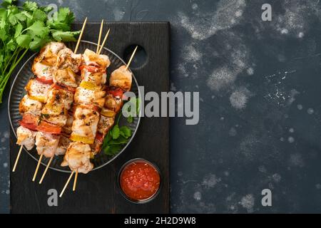 Pollo shish kebab o spiedini kebab in un piatto di ceramica, spezie, erbe coriandolo e verdure su sfondo bianco tavolo. Barbecue ingredienti crudi per Foto Stock