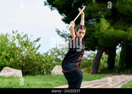 Donna pratica kung fu con un bastone Foto Stock