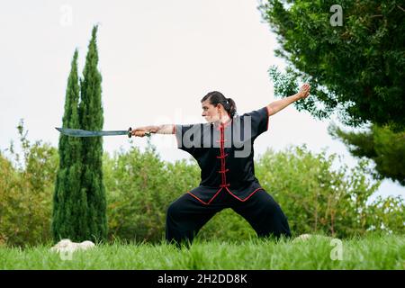 Donna in uniforme pratica arti marziali con una spada Foto Stock