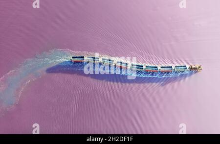 Estrazione del sale sul lago rosa con un treno speciale e carrozze. Vista dall'alto dal quadricottero Foto Stock