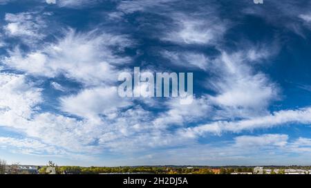 Cielo amichevole con varie formazioni di nuvole - cirro e cumuli su un paesaggio urbano Foto Stock