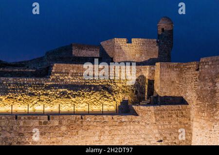 Vista serale del Forte Qal al-Bahrain illuminato nel Bahrain Foto Stock