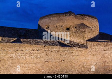 Vista serale del Forte Qal al-Bahrain illuminato nel Bahrain Foto Stock