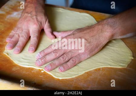 Preparazione di pasta per tagliatelle, gnocchi. Impasto a base di farina di grano. Foto Stock