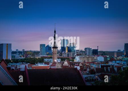 Skyline di Tallinn al tramonto con la Torre del Municipio e gli edifici moderni del Centro Città sullo sfondo - Tallinn, Estonia Foto Stock