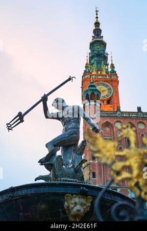 Danzica, Polonia. Statua di Nettuno in una fontana, simbolo della città. Municipio sullo sfondo. Foto Stock