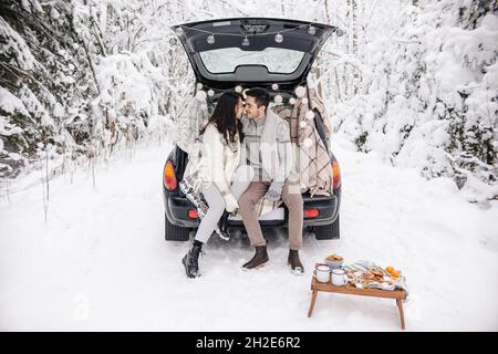 Coppia carina che ha Winter Forest picnic. Picnic natura. Data storia dell'amore in macchina. Foto Stock