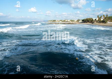 Agia Marina resort, Creta, Grecia bella scena balneare con onde e surf breaking sulla spiaggia aspetto paesaggistico con spazio copia Foto Stock