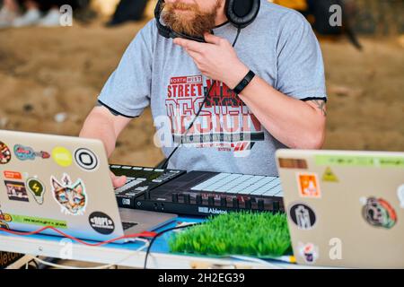 Svetlogorsk, Russia - 08.14.2021 - disco jockey che suona musica, remixing su controller midi drum machine. DJ suona il campionatore di battute con drum pad e sam Foto Stock