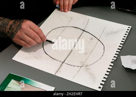 CITTÀ DEL CAPO, SUDAFRICA - Apr 21, 2021: Un maschio che disegna un ritratto con una matita su un foglio a Città del Capo, Sudafrica Foto Stock