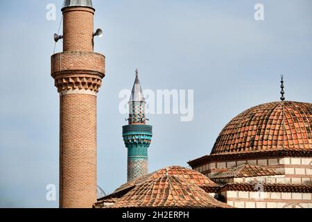 seyh kutbuddin e la sua tomba figlio fatta di mattoni rossi muro con il suo minareto si estende al cielo blu nuvoloso con sfondo verde moschea (yesil cami). Foto Stock