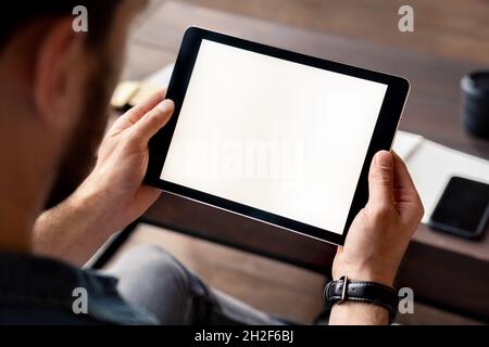 Uomo che tiene il tablet digitale schermo bianco in vista mano sopra la spalla Foto Stock