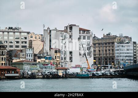 Riva Karakoy di istanbul e molti traghetti pedonali ancorati in corno d'oro con piccola barca da pesca durante la giornata colma e piovosa di istanbul. Foto Stock