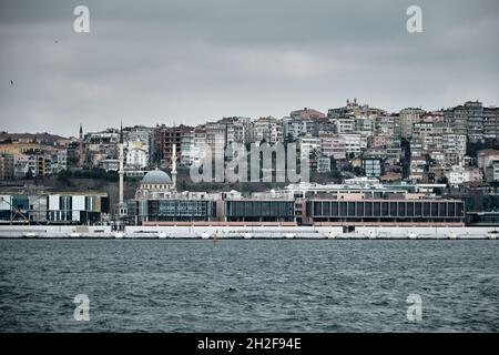 Vergogna sulla riva di Tophane. Nuovo edificio costruito attraverso il bosforo di fronte alla vecchia moschea ottomana (kilic ali pasa cami) Foto Stock