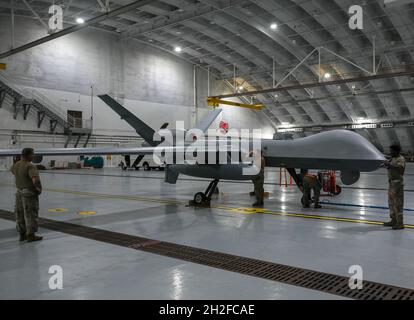 Gli airmen del 556th Test and Evaluation Squadron preflight un MQ-9 Reaper alla Andersen Air Force base, Guam, 4 ottobre 2021. Il Reaper è stato volato dalla base del corpo Marino, Hawaii, durante la sua partecipazione in esercizio Ace Reaper. Lo scopo di ACE Reaper è quello di dimostrare le capacità dei membri del MQ-9 e le capacità dei membri del servizio di mobilitarsi e integrarsi rapidamente in più domini. L'esercizio serve anche come opportunità di formazione in un ambiente marittimo e in uno spazio aereo diverso. (STATI UNITI Air Force foto di staff Sgt. Divine Cox) Foto Stock