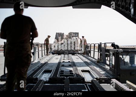 Gli airmen assegnati al 386a Expeditionary Logistics Readiness Squadron caricano il carico in un C-17 Globemaster III assegnato al 5th Expeditionary Air Mobility Squadron alla Ali al Salem Air base, Kuwait, 20 ottobre 2021. Nona Air Force Airmen sono in grado di garantire e stabilizzare l'area di responsabilità del comando Centrale degli Stati Uniti, fornendo tattiche di sollevamento dominante insieme ai nostri alleati e partner. (STATI UNITI Air Force foto di Senior Airman Michael S. Murphy) Foto Stock